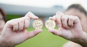 Two hands, each holding up a recovery coin that reads "I am a Miracle"